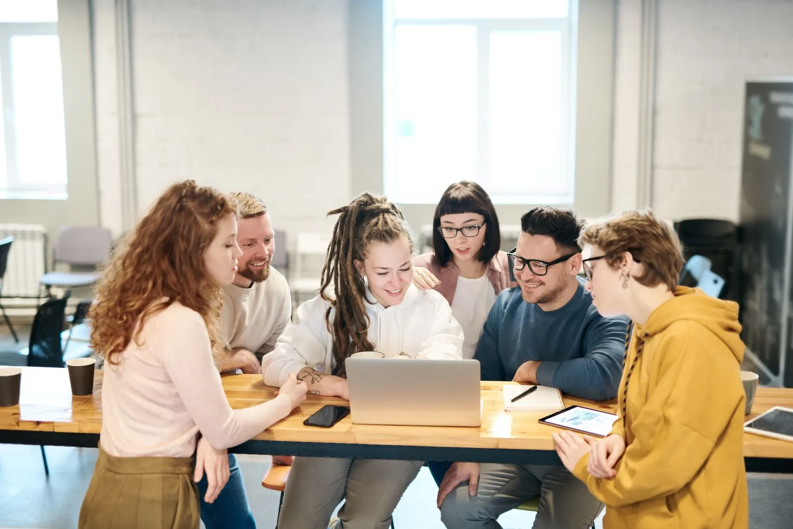A small team gathered around a laptop, reviewing a project together